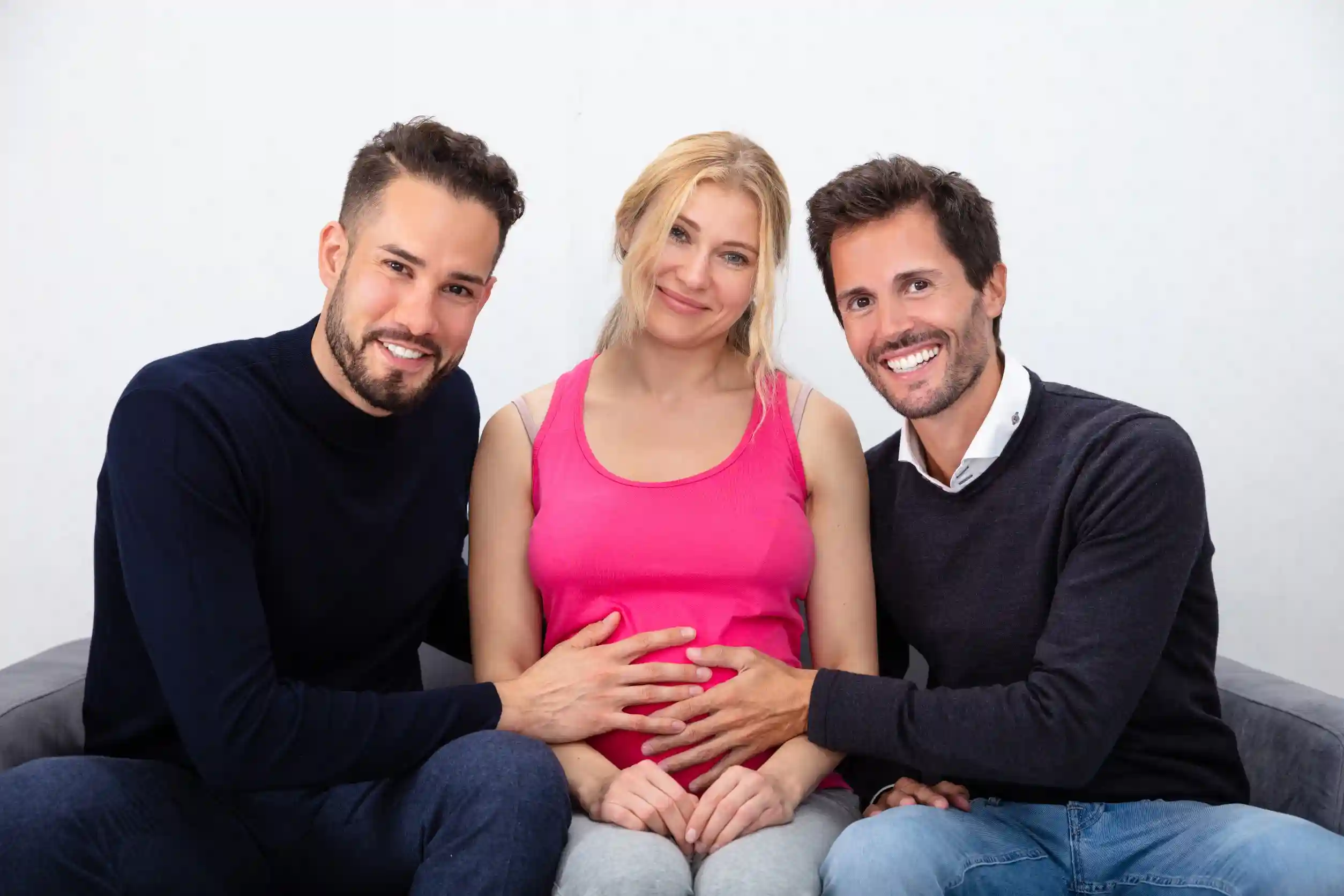 Portrait Of Smiling Men Touching The Belly Of Pregnant Surrogate Woman
